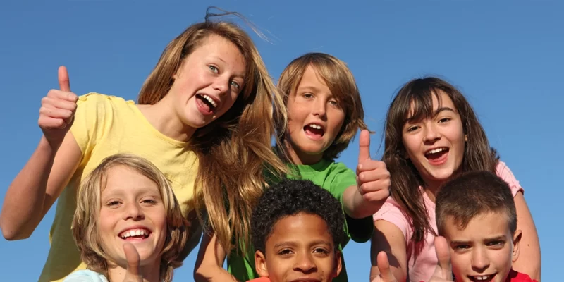Groups of teenagers giving a thumbs up sign